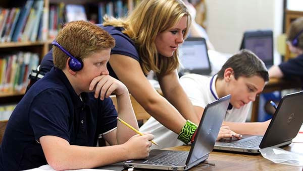 Grace Goode, 13, center, helps out Jack Godwin, 13, and Joshua Johnson, 13,  with the new Virtual Virginia online Spanish program. -- CAIN MADDEN | TIDEWATER NEWS