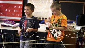 Daniel WInne, 7, left, and Wade Draughn, 6, hold strings of yarn as a way to learn about other students. -- CAIN MADDEN | TIDEWATER NEWS