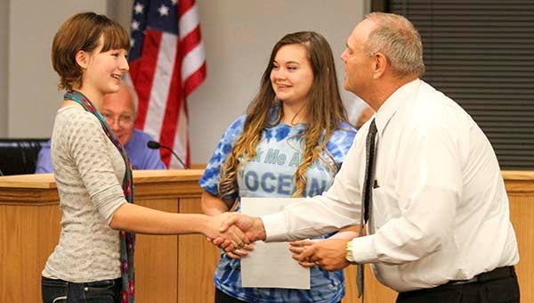 Vanessa Stone, left, and Angela Bird, center, are presented a resolution by Councilman Barry Cheatham Monday night proclaiming Oct. 4 “GREEN Day,” which stands for Growing Recycling Efforts for the Environment Now. -- CAIN MADDEN | THE TIDEWATER NEWS