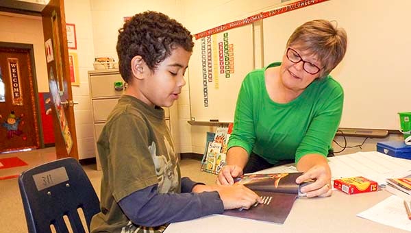 Ralphie Elliott, 7, of Riverdale Elementary School, reads a book with the help of Carolyn Lowe. She’s been a tutor with the Lifesavers for Reading program for three years, and wants to increase her time spent helping students to read. -- STEPHEN H. COWLES | THE TIDEWATER NEWS