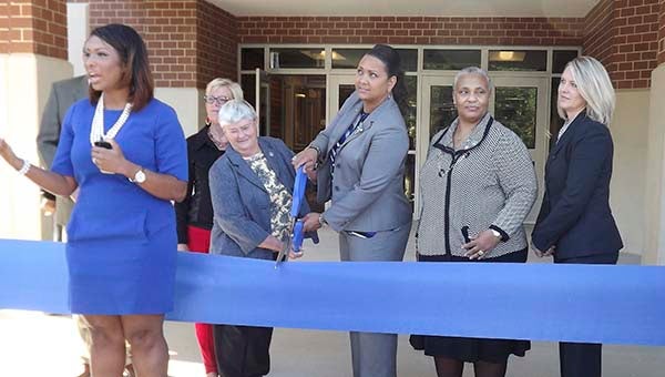 In front, Kenita Bowers, Isle of Wight County School spokeswoman, welcomes people to the dedication of the Georgie D. Tyler Middle School in WIndsor. Behind her, Isle of Wight School Board Chairwoman Julia Perkins, left, and Supt. Dr. Katrise Perera are ready to cut the ribbon. With them are board members Kent Hildebrand, Tina HIll, Denise Tynes and Principal Susan Goetz. -- STEPHEN H. COWLES | TIDEWATER NEWS