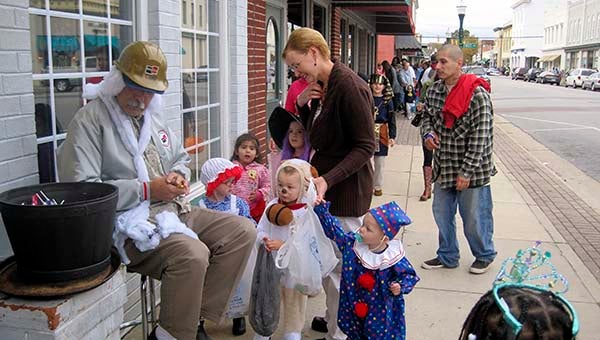 Children stop by Fred’s Restaurant to see David Rabil, who is handing out candy and dressed up as an old Union Camp worker.  -- SUBMITTED | DAN HOWE