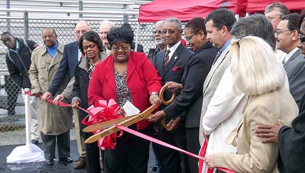 Southampton School Superintendent Dr. Alvera Parrish, in red, and Dr. Deborah Goodwyn, board chairwoman, cut the ribbon to dedicate the new track at Southampton High School. With them are other school board members and county supervisors. -- Andrew Lind | Tidewater News