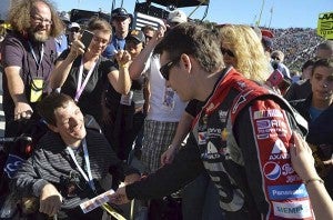 Before the race, Jeff Gordon signs an autograph for a fan. -- Jim Hart | The Tidewater News