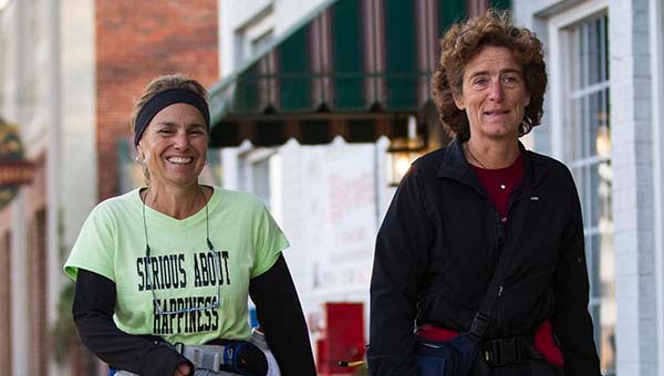 Paula Francis, left, and Linda Wheatley walk through downtown Franklin as they were here on their way South promoting happiness.