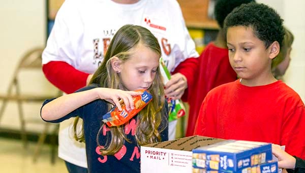 Averery Rose, 7, places some crackers into a box. WIth her is Isaiah Oliver, 8. -- CAIN MADDEN | TIDEWATER NEWS