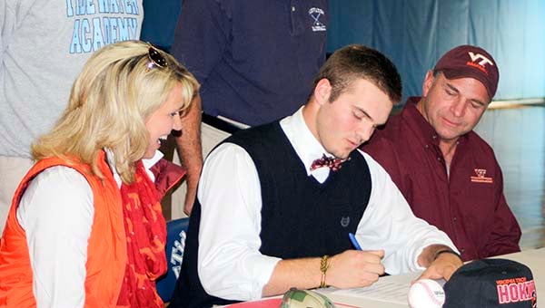 Tidewater Academy’s Peyton Holdsworth signs papers to play for the Virginia Tech Hokies. With him are his parents, Martha and Walter Holdsworth. -- SUBMITTED