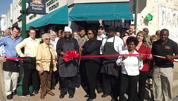Surrounded by staff, family, friends and downtown Franklin business supporters, Douglas Sumblin and Mayor Raystine Johnson-Ashburn prepare to the cut the ribbon for the grand reopening of Mr. D’s Southern Kitchen and Catering, which is located at the corner of Main Street and First Avenue. -- Stephen H. Cowles | Tidewater News