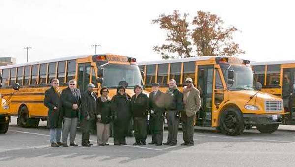 Dr. Alvera J. Parrish, center, and several members of the school board and supervisors stand in front of the recently purchased school buses. -- SUBMITTED