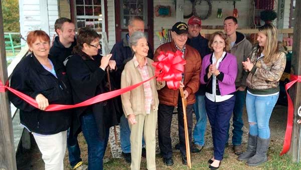 June and John Fox, the building owners at center, are ready to cut the ribbon for Vintage Country Charm, which opened earlier this month. With them from left, are Diane Craddock, Jeremy Lamm, Dorothy Greene, James Greene, Marty Greene, Carol Craddock, Josh Hill and Morgan Buonanduci. -- SUBMITTED