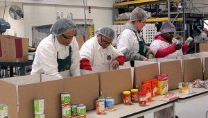 Employees at Hubbard Peanut Company pack food into boxes that will go to feed families. -- Courtesy