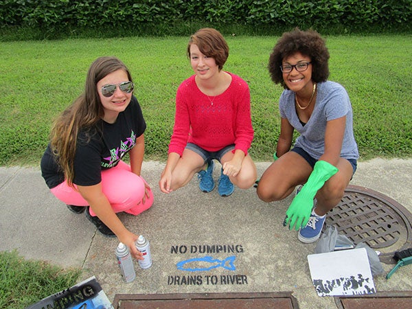 From left to right, Angela Bird, Vanessa Stone and Summer Winston of Project Pollution Preventers, the Community Project Solvers team tackling recycling downtown. Over the summer, they were also concerned with drainage entering the river, which exits into the ocean, where trash builds up and endangers wildlife. Parents worry that the future of this program is in jepardy after the system reduced one of the system’s two gifted instructors.