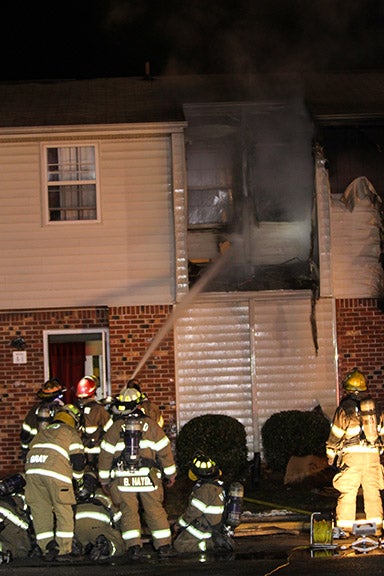 Fire crews work to put out the embers in the wall of a Dorchester Square Apartment on Thursday. Photo by Cain Madden.