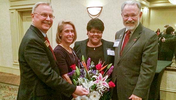 Dr. Candace Rogers, third from left, receives a bouquet in addition to an award for her past leadership in the nursing program at Paul D. Camp Community College. At left are Dr. Paul Wm. Conco, president; Carole Wright, faculty; and Dr. Doug Boyce, president emeritus. -- Stephen H. Cowles | Tidewater News