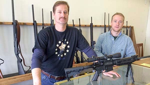 Mike Miller, left, and Mike Oden of South Eastern Armament Company LLC, display some of the many rifles they have available for sale. The store is located at the Airway Shopping Center on Carrsville Highway in Isle of Wight County. -- Stephen H. Cowles | Tidewater News