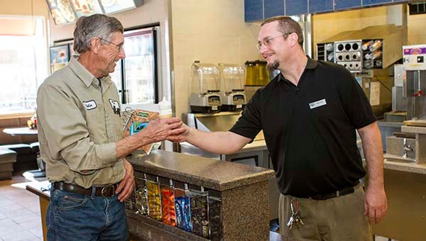 Franklin Dairy Queen manager Daniel Stratton, right, hands off an ice cream cone to Eddie Dunlow of Murfreesboro, North Carolina. On Monday, the company is celebrating its 75th anniversary by giving away free 5-ounce cones on the 75th day of the year. -- Cain Madden | Tidewater News