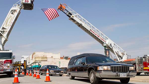 The funeral procession for Fred Rabil passes by Fred’s Restaurant on the way to the graveside service. The Franklin and Carrsville Fire and Rescue departments draped a flag above the street for the iconic Franklin resident. -- Cain Madden | Tidewater News