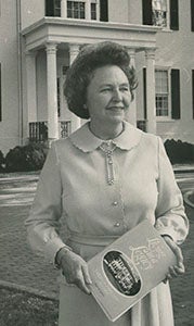 Katherine Godwin shows off her book, “Living in a Legacy,” on the grounds of the Virginia governor’s mansion in this undated photo provided courtesy of Riddick’s Folly, which has an extensive exhibit on Godwin and her husband, the late Mills Godwin Jr. She died Thursday.