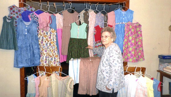 Kathleen Grizzard shows several of the outfits that she’s created. These clothes will be sent overseas later this season. -- SUBMITTED