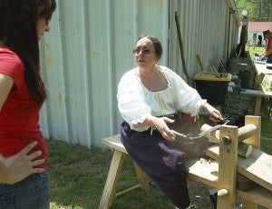 Dawn James of Portsmouth demonstrates how to work a shaving horse. -- MERLE MONAHAN | TIDEWATER NEWS