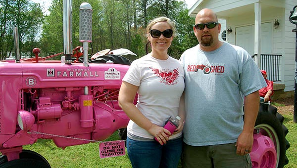 Leslie and Chuck Sabostand beside their pink tractor.  He said he painted the tractor for his wife, Leslie.  She plans to enter it in parades and fundraisers. -- MERLE MONAHAN | TIDEWATER NEWS