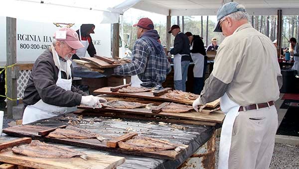 Gene Brittle, left, and Jimmy Lane put the fish on the planks for the annual Shad Planking event, hosted by the Wakefield Ruritan Club. This year’s event will be on the grounds of the Wakefield Sportsman’s Club at 12205 Brittles Mill Road, four miles west of town. -- FILE PHOTO