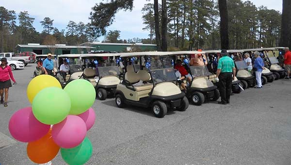 Golfers prepare their carts for 18 holes at Cypress Cove Country Club. -- SUBMITTED