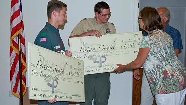 Forrest South, left, and Brian Cooke, right, receive the mock checks from Theresa and Jimmy Henderson, who started a scholarship in the name of their son. Scouts were a big part of Eric V. Henderson’s life, so the scholarship is awarded to local Boy Scouts. -- Walter Francis Jr. | Tidewater News