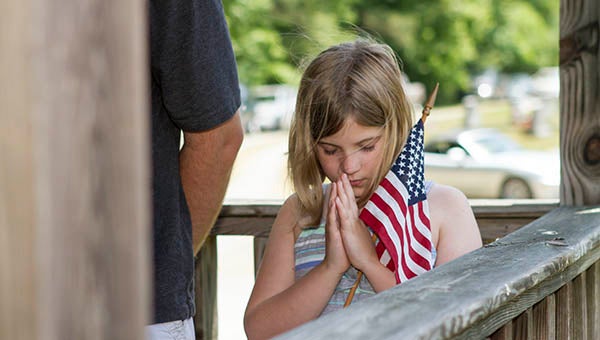 Laney Phillips, 9, of Franklin, prays as the Rev. Howard Vinson of Hunterdale Baptist Church offers the Invocation for the Charles R. Younts American Legion Post 73’s Memorial Day Ceremony on Monday. Vinson, the chaplain of Post 73, also told the story of the four chaplains who gave their life preservers and ultimately their lives as the SS Dorchester went down in WWII. -- Cain Madden | Tidewater News