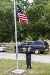 As Blaine Britt plays “Taps,” Kenny Gay, a member of the Charles R. Younts American Legion Post 73, lowers the flag to half mast in honor of the veterans who gave the ultimate sacrifice. Cain Madden | Tidewater News