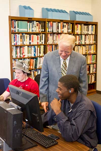 Interim Paul D. Camp Community College President Dr. William Aiken looks over the shoulder of Franklin resident Dalvonte White, who was on campus to use the internet. Caleb Dundlow, a first year student, works on some homework nearby.