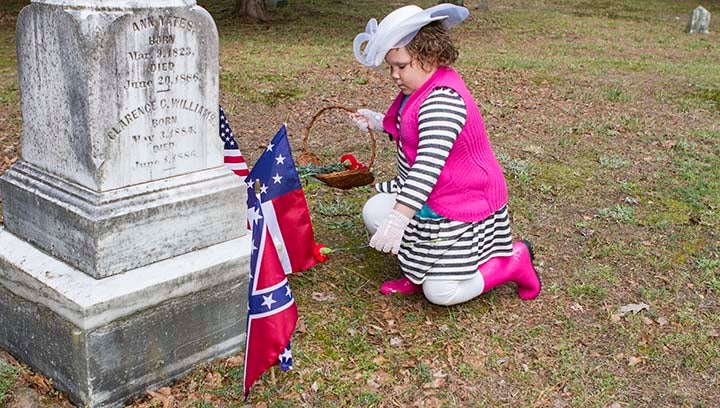 Mia Porter, 7, places the flower on the gravestone of a local who was a part of the American Civil War.