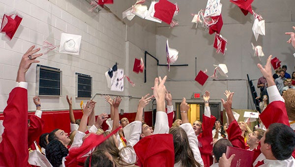 Isle of Wight Academy seniors throw their caps in the air to celebrate after the graduation ceremony on Friday evening. The students will attend schools as close as Paul D. Camp Community College, and as far away as Brigham Young University. -- Cain Madden | Tidewater News