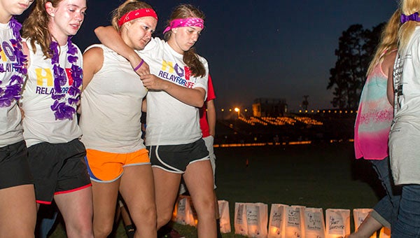 Southampton High School students Sarah Williams, Adelaide Dwyer, Meghan Simmons and Brittany Bunn comfort each other as they make the final lap of Relay For Life. -- Cain Madden | Tidewater News
