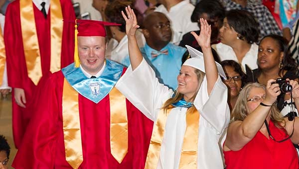 Meghan Simmons gives a wave to the crowd as she walks down the aisle on Saturday afternoon at the Southampton High School graduation. -- Cain Madden | Tidewater News