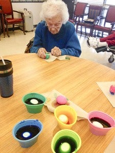 Mildred Doughtey dying eggs and reminiscing about all the Easters past doing this project with her girls. East Pavilion was visited by the Gingerbread Kids and hosted an Easter Egg hunt for them. -- FILE PHOTO