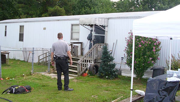 Sgt. Mark Turner of the Southampton County Sheriff's Office watches a Drug Enforcement Administration officer enter mobile home in Boykins. A probation officer visit revealed a "shake and bake" meth apparatus inside the home. -- Submitted | Camden Cobb