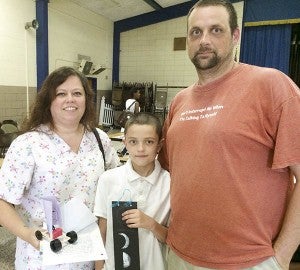 Christian Cutchins, 10, with his parents, Jill and Bud Cutchins at S.P. Morton Elementary School’s ceremony to conclude the summer school program. -- Stephen H. Cowles | Tidewater News