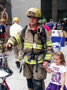 After the firefighters completed the stair climb, they got to ring the bell and announce in a microphone who they walked for during the 9/11 Memorial Stair Climb. Pictured are Frankling Firefighter Scott Maynard and his youngest daughter, Addie. -- SUBMITTED