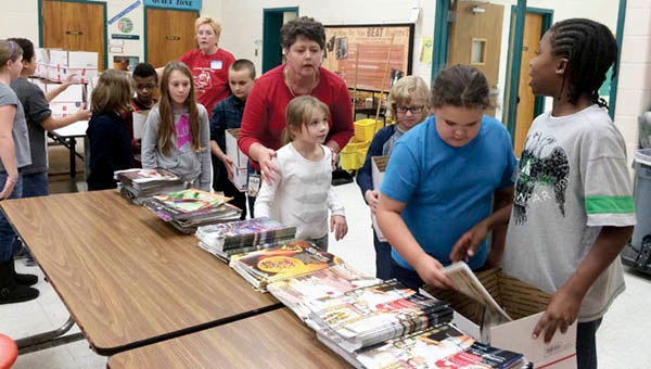 Carrsville Elementary students Kendall Brinkley, 8, and Taeviyon Holland, 10, lead the assembly line for putting items in boxes. -- STEPHEN H. COWLES | The Tidewater news