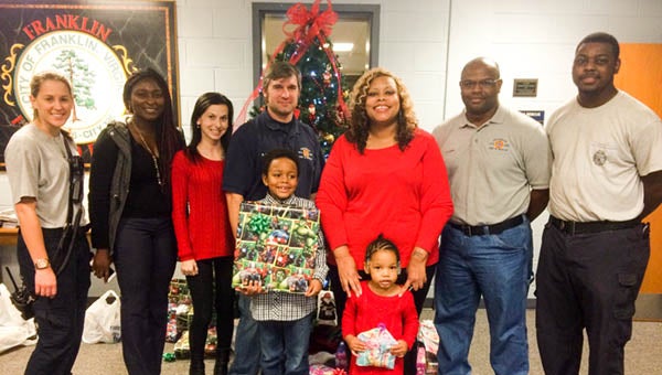 Members of the Franklin Firefighters and Medics Association Local 4517, Franklin Fire and Rescue Volunteers and Franklin Social Services donated Christmas presents and meal to a needy family. Pictured are Samantha White, Alice Adoga, Jennifer McReynolds, Scott Maynard, Markiquita Holloman and her children Joshua and Joy, Wendall Lowe and Charles Smith. -- Rebecca Chappell | Tidewater News