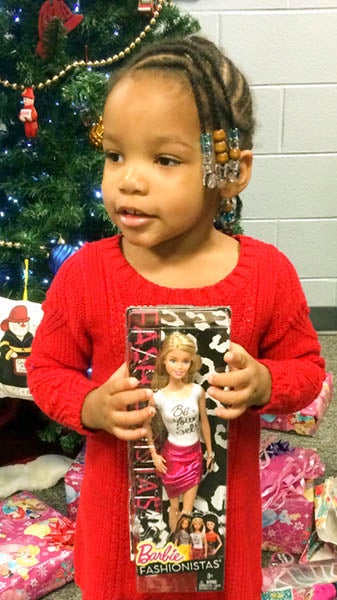 Joy Holloman, 2, holding the Barbie she received as one of her Christmas gifts. -- Rebecca Chappell | Tidewater News