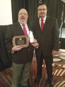 At left is Stephen H. Cowles, a staff writer at The Tidewater News, holding the awards the paper received on Tuesday from the Virginia Farm Bureau Federation for coverage of agriculture and forestry in the past year. The plaque notes the paper’s contributions in its category as a non-daily newspaper. The other, the Ishee-Quann Award for Media Excellence, recognizes the best of all entries in the VFBF’s annual competition. With him is VFBF President Wayne F. Pryor. -- Submitted | Virginia Farm Bureau Federation