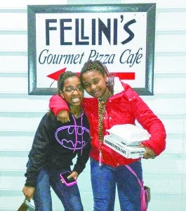 From left, sisters Sierra and Ivanna Brown stand with their leftovers in front of Fellini’s, which is in Norfolk.