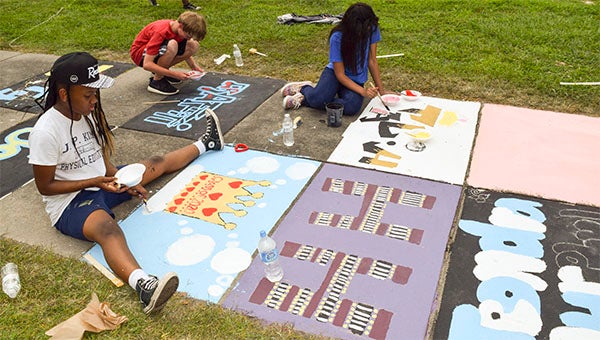 Students at J.P. King Middle School stayed after school to complete their sidewalk art piece with images, words and phrases that represent who they are individually and who they are as a class. -- Rebecca Chappell | Tidewater News