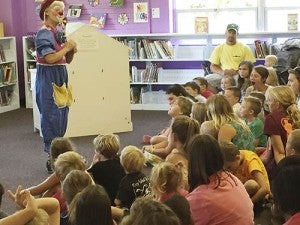 Joy the Clown performs magic tricks while teaching her audience of young readers the importance of reading, obeying one’s parents and practicing kindness during the 2015 summer reading program at the Walter Cecil Rawls Library in Courtland. -- FILE