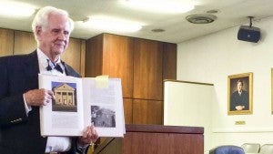 John O. Peters points to the Southampton County Courthouse as it stands now, pictured in his book, “Virginia’s Historic Courthouses.” At right is the building before existing additions. He spoke on the topic of courthouses at the Southampton site on Sunday afternoon. -- Stephen H. Cowles | Tidewater News