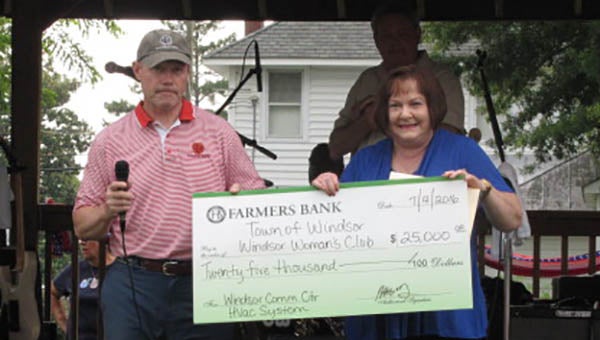 Farmers Bank President RIchard Holland Jr. presents an oversized $25,000 check to the Town of Windsor and Windsor Woman’s Club. Receiving the gift is Mayor Carita Richardson. She’s one of many people who have been working to convert an old gymnasium into a new community center. -- SUBMITTED | Jessica Slaba